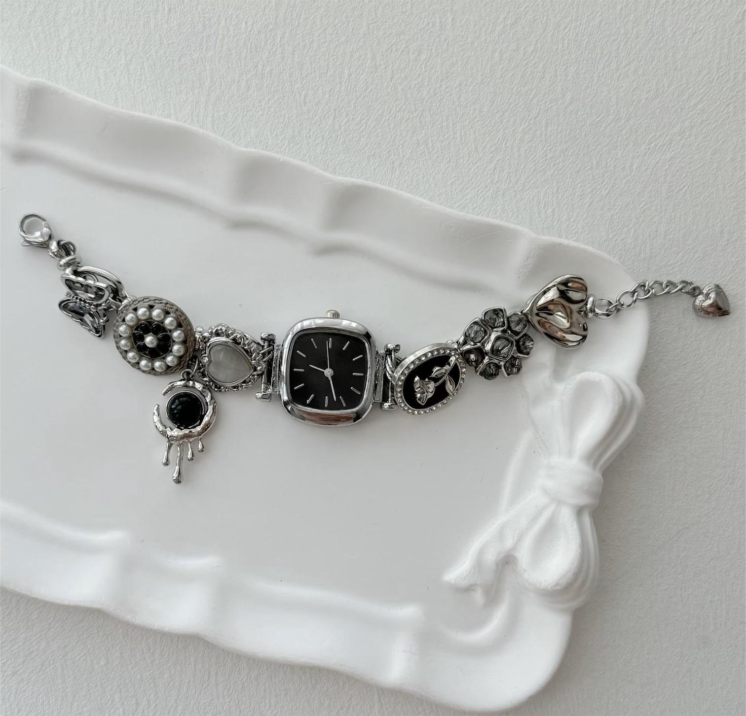 Stainless steel bracelet watch crafted by hand featuring button fastening and charm arrangement for Swift fans
