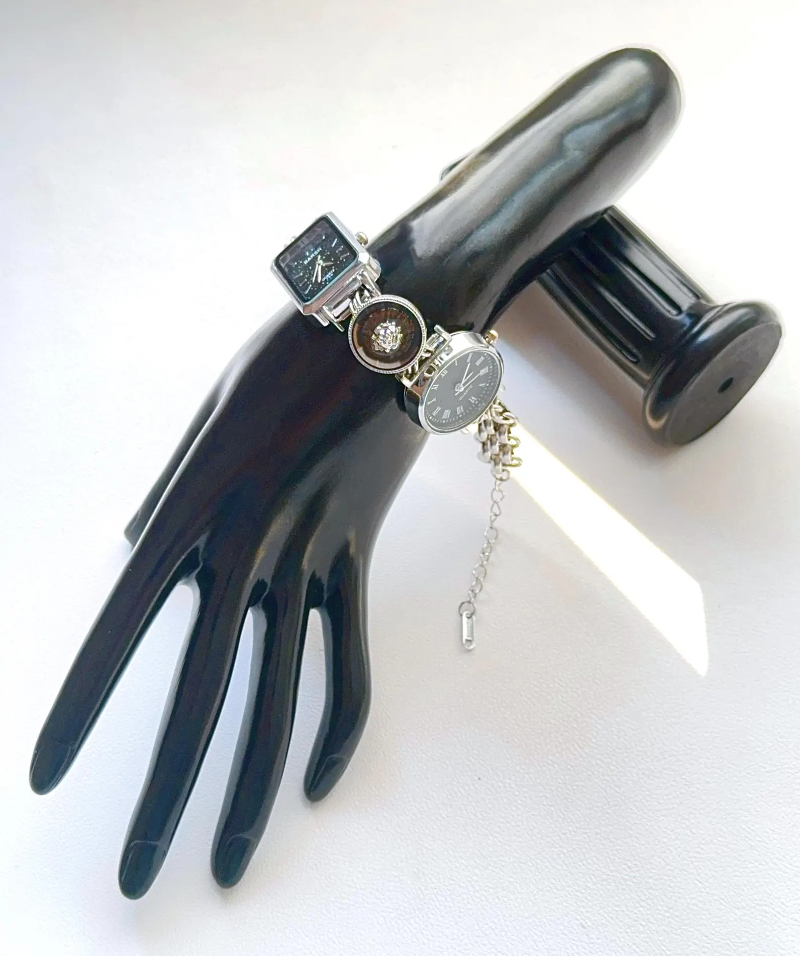 Raw-edge fashion bracelet watch reflecting charm loops and pressable button slots