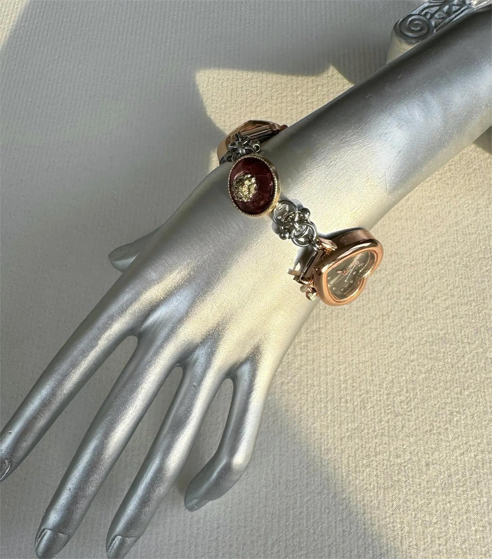 Hand-assembled titanium bracelet watch including compact buttons and curated charms