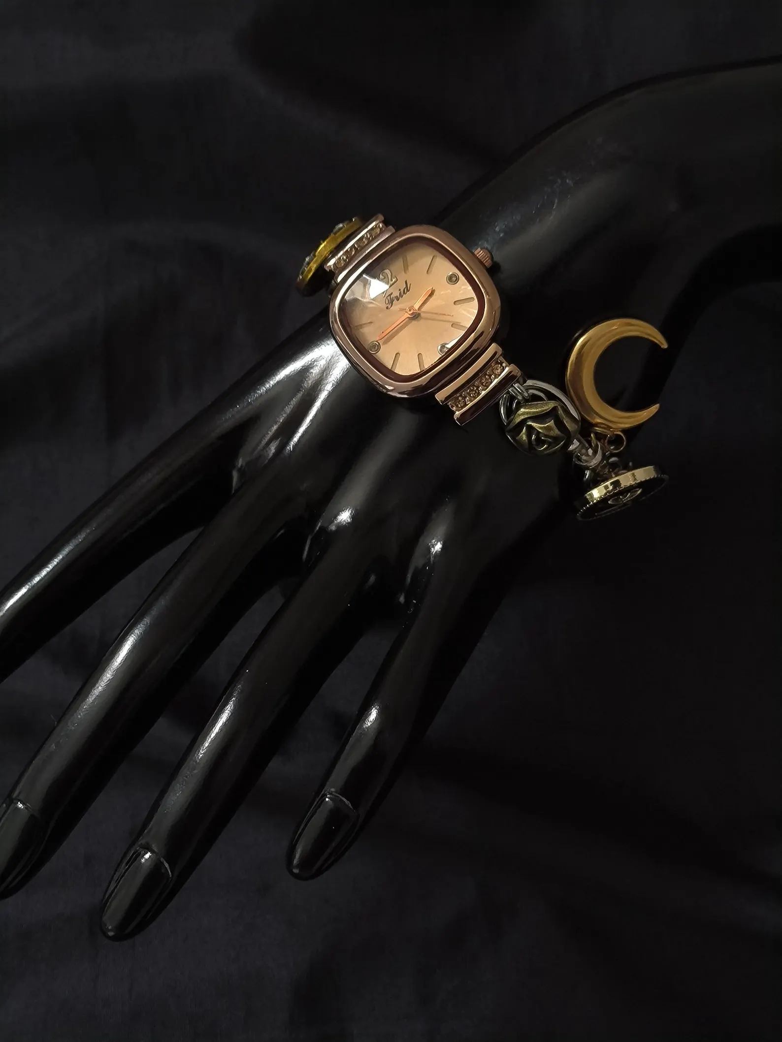 Cyber-styled wristwatch bracelet shaped for rotating charm loops and button bezels