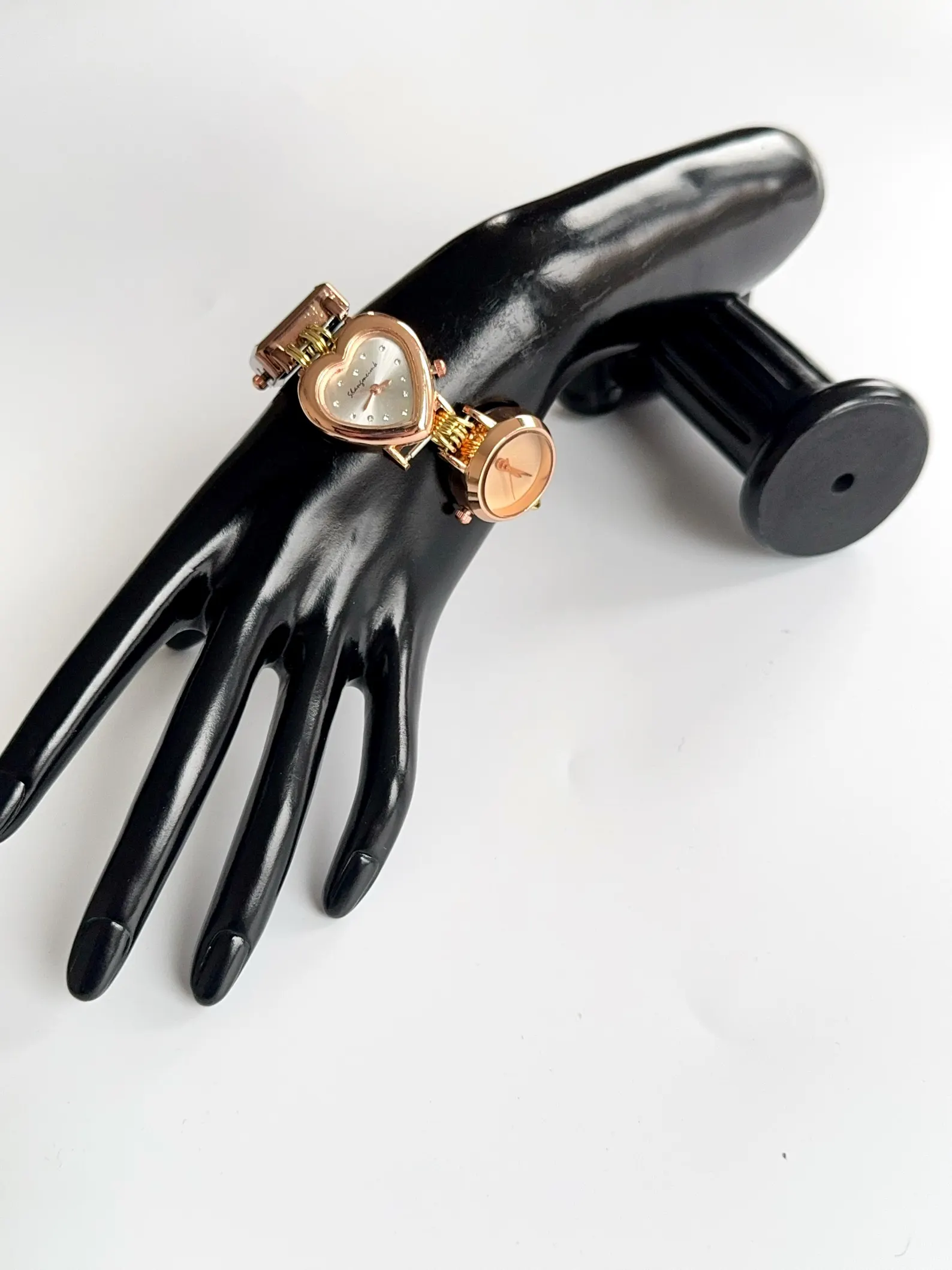 Y2K-inspired bracelet watch highlighting layered charms and sculpted buttons