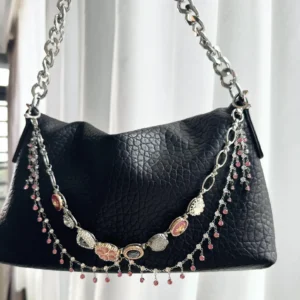 A delicate layered purse adorned with pink floral charms, featuring a stylish chain strap, perfect for adding a touch of feminine elegance to any outfit.