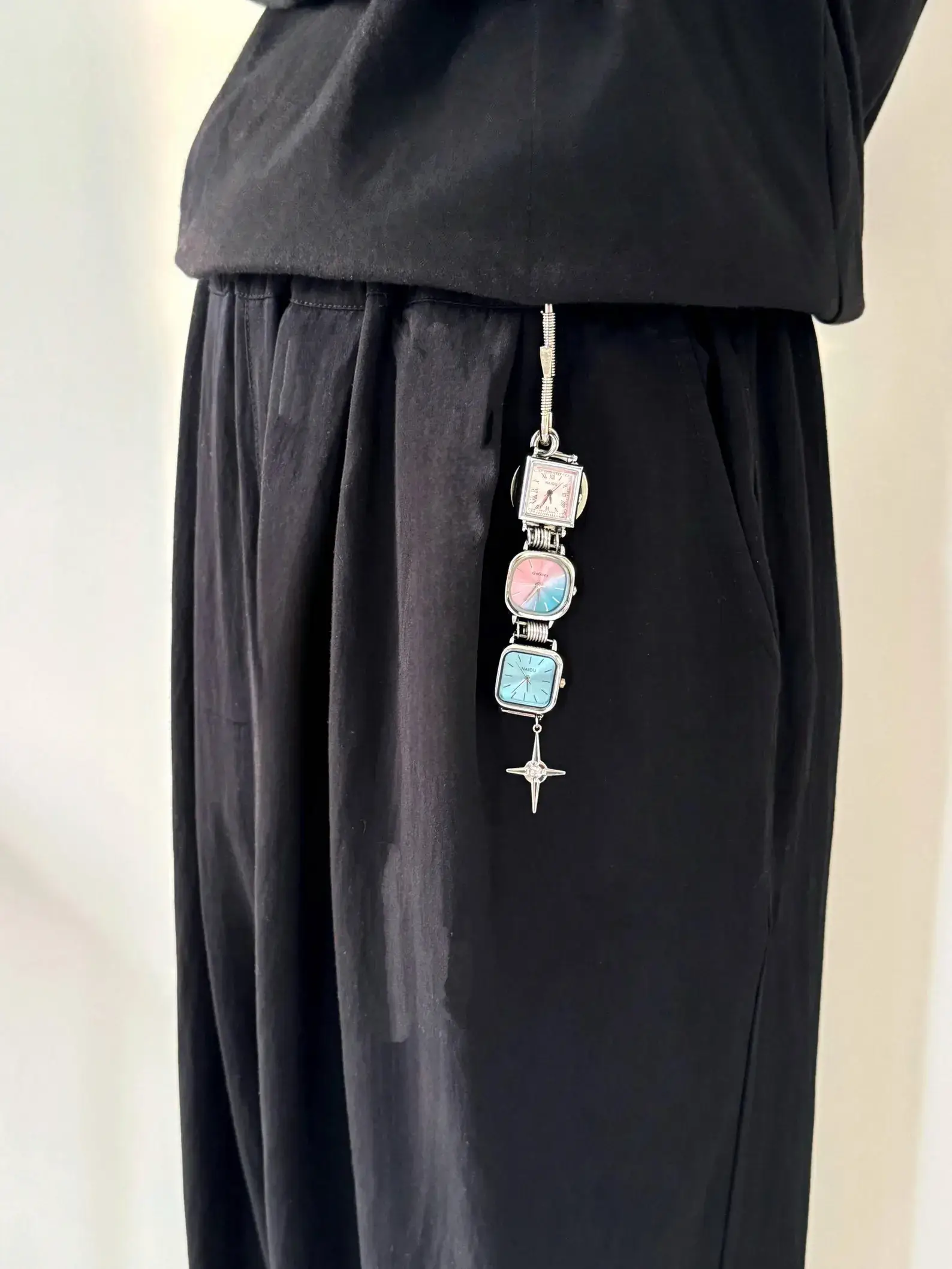 Y2K celebrity minimalist watch keychain: A sleek silver or black titanium chain with a small functional minimalist watch and subtle charm, worn as a keyring accessory, capturing the iconic early 2000s celebrity style with modern unisex appeal.