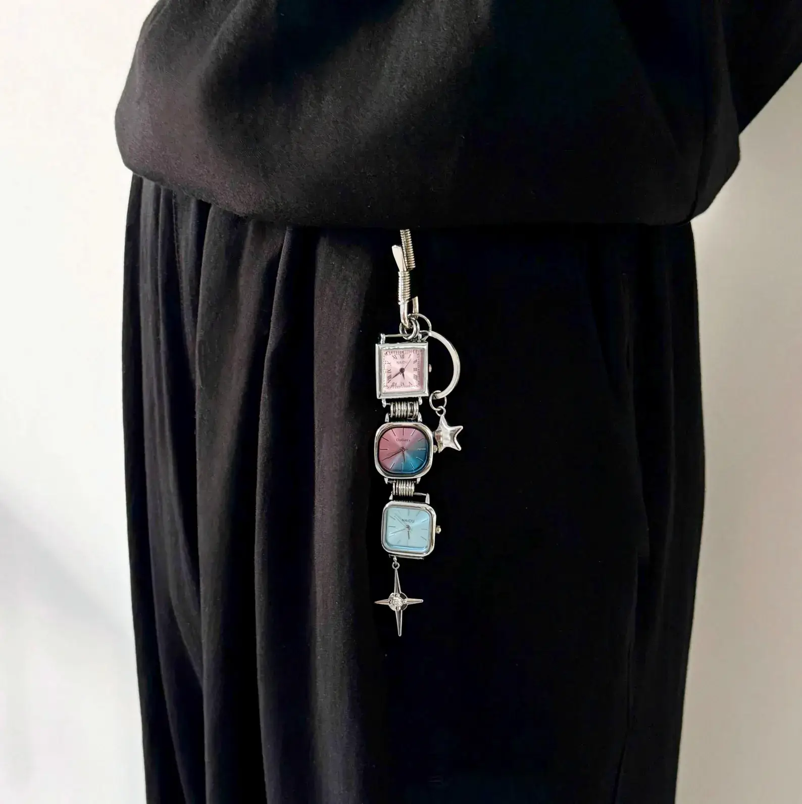 Y2K celebrity minimalist watch keychain: A sleek silver or black titanium chain with a small functional minimalist watch and subtle charm, worn as a keyring accessory, capturing the iconic early 2000s celebrity style with modern unisex appeal.